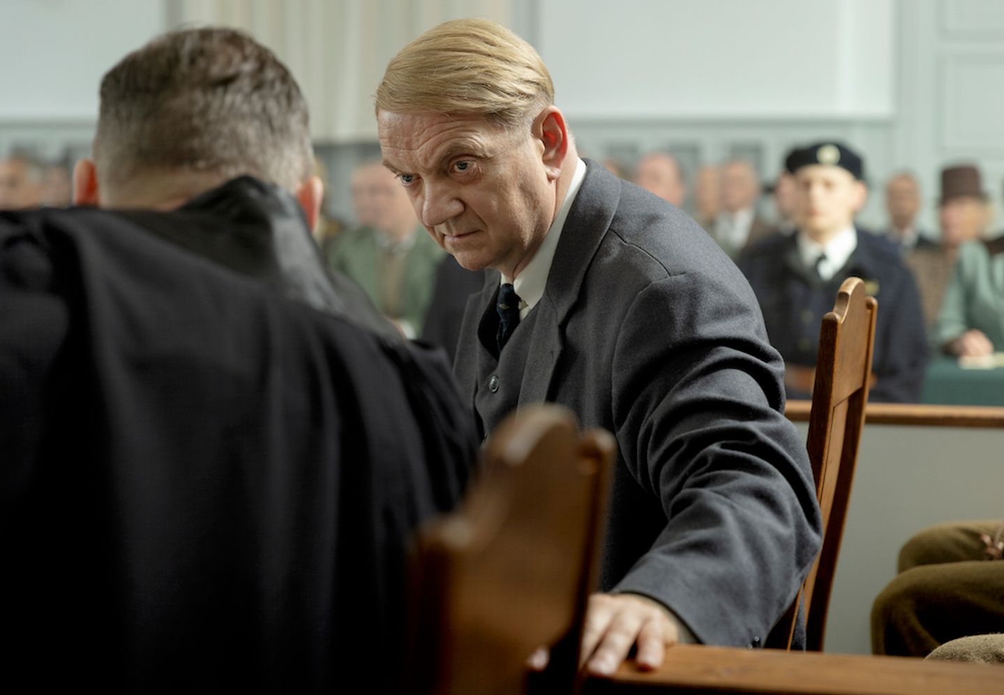 a man in a suit and tie talking to another man in a suit