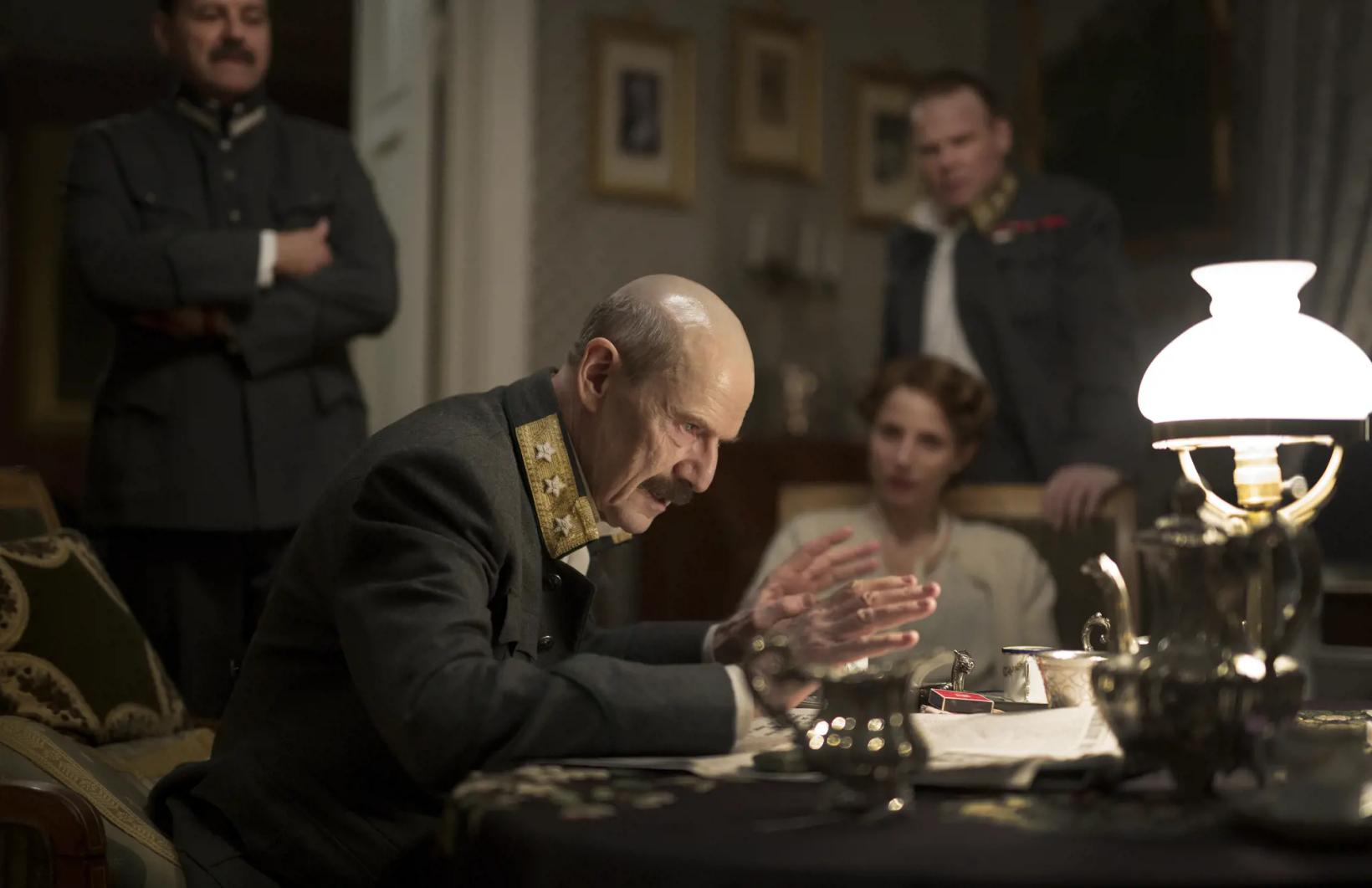 a man sitting at a table with a group of people around him