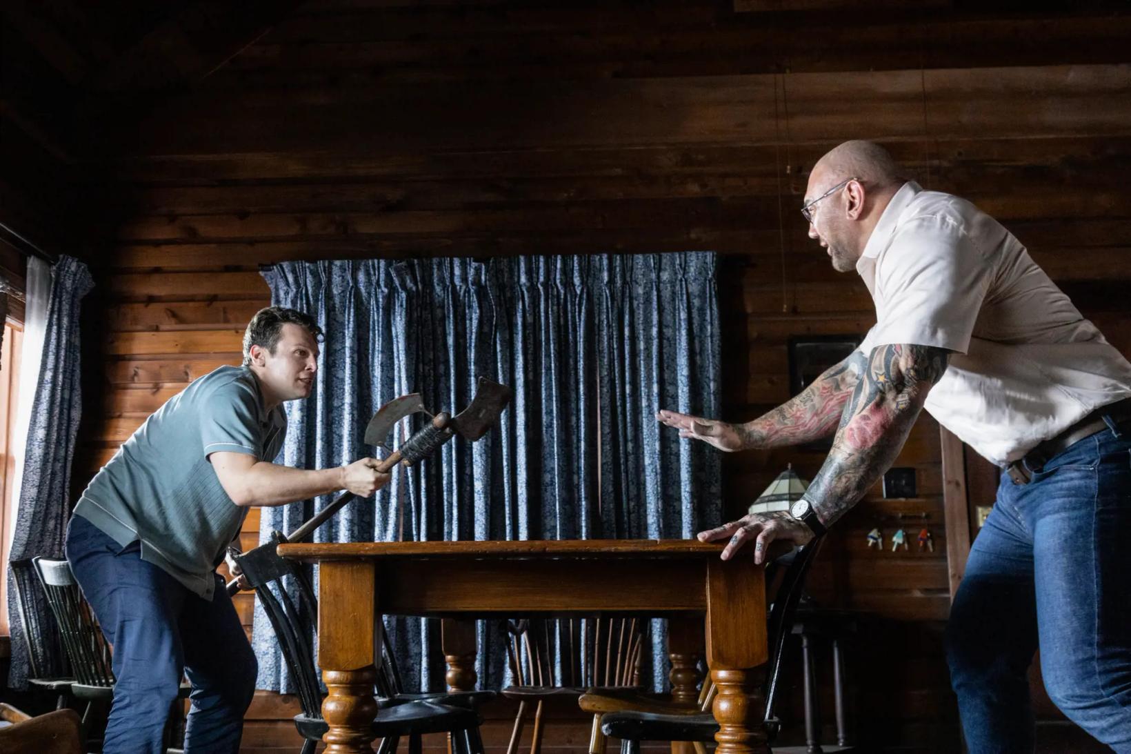 a man playing a piano with a man holding a knife