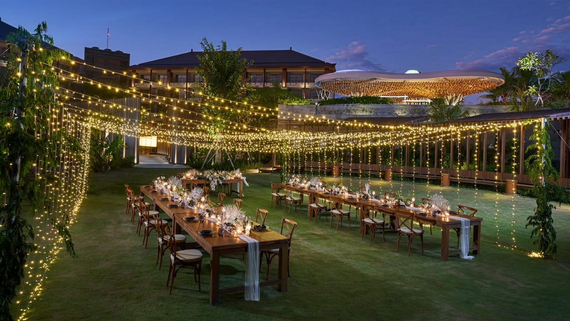 Poolside outdoor wedding reception with long dining tables and warm string lights