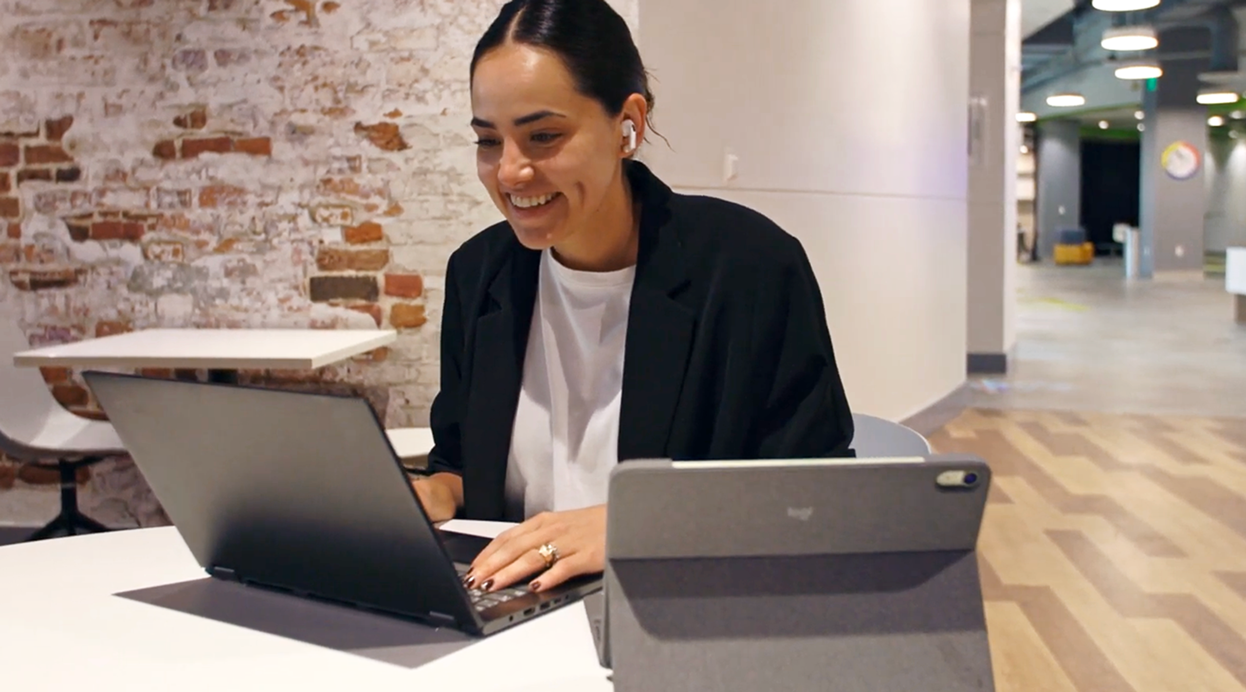 PeakActivity team member working on a laptop and tablet in the office