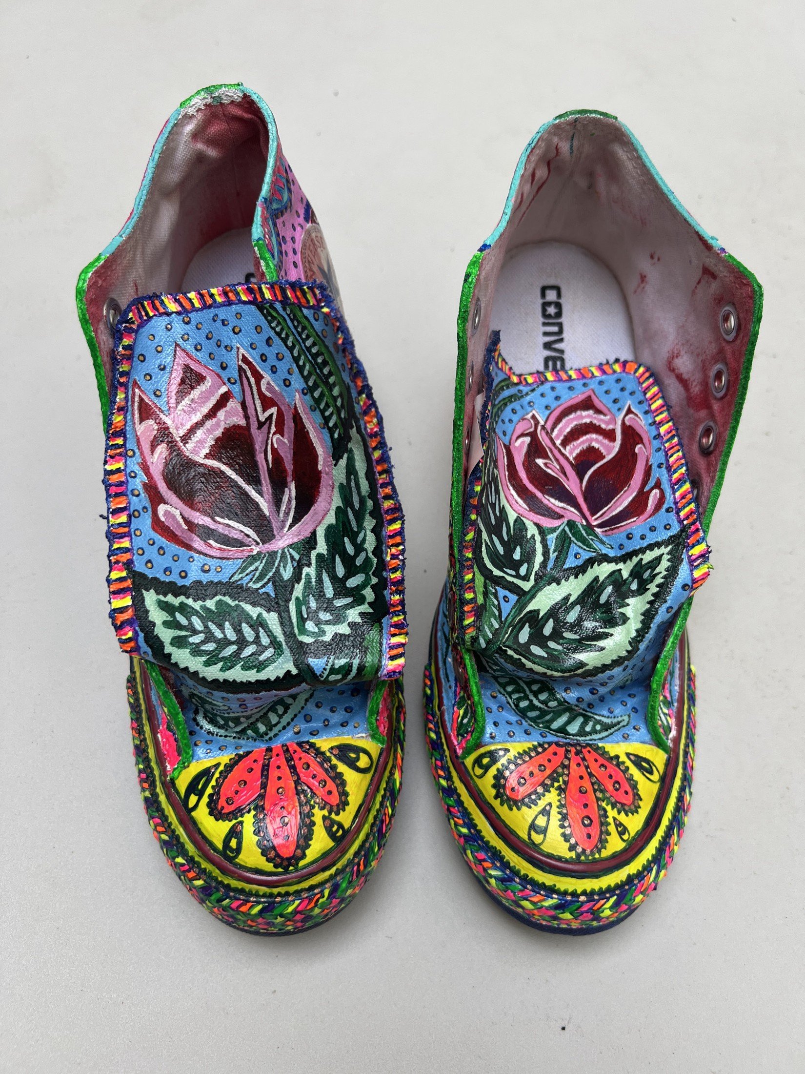 Top view of hand-painted high tops with floral designs