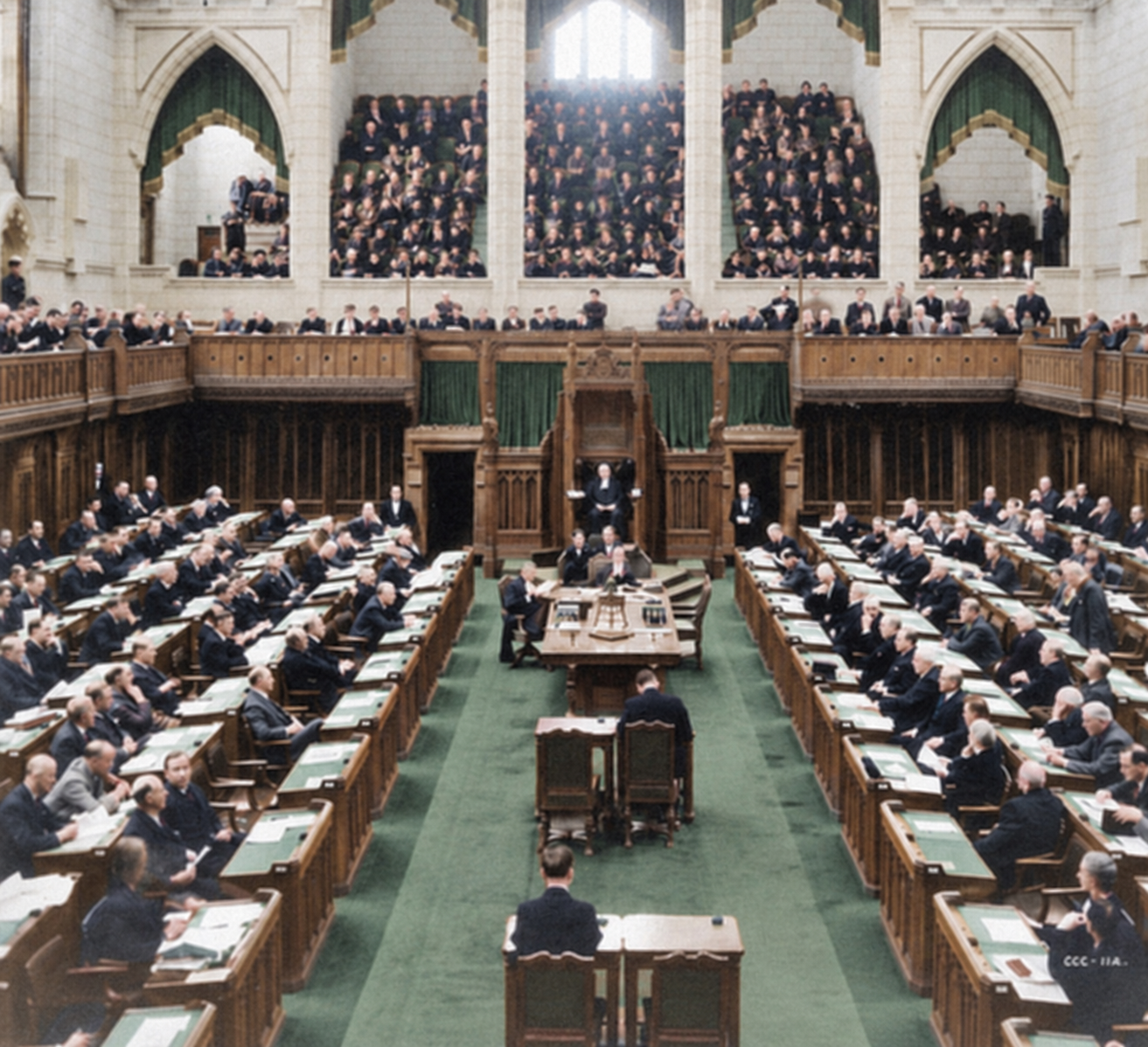 Wide view of Canada's House of Commons chamber, with members seated at desks on both sides and spectators in the galleries.
