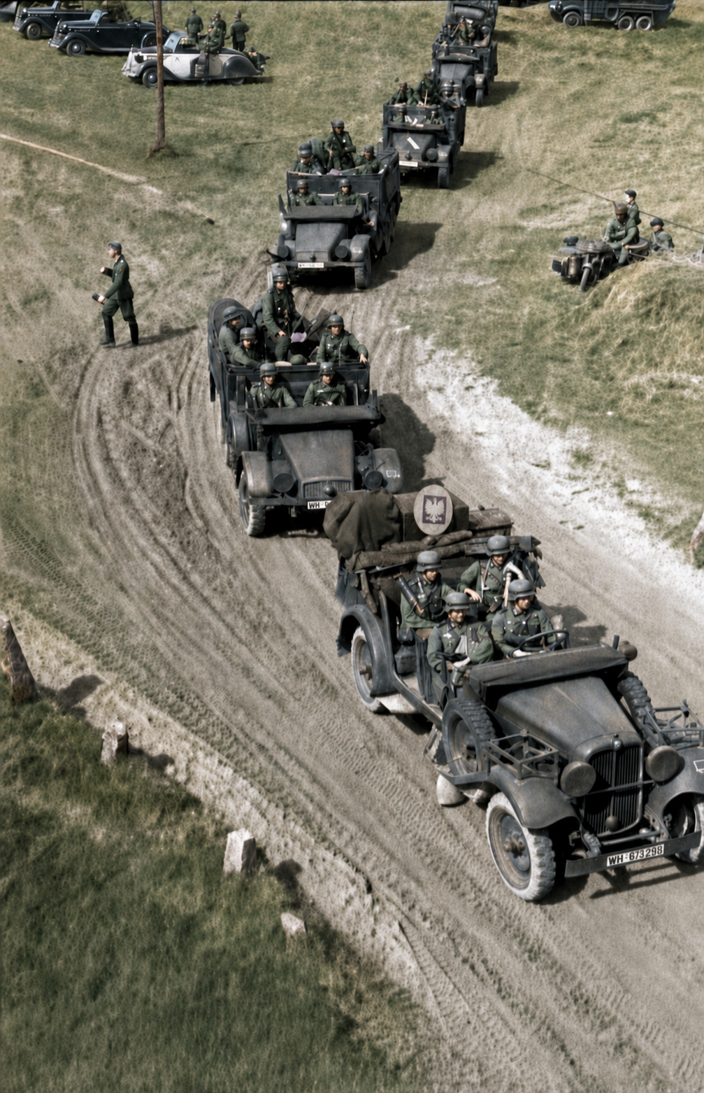 German motorised troops and vehicles form a long column on a rutted road through open Polish countryside.