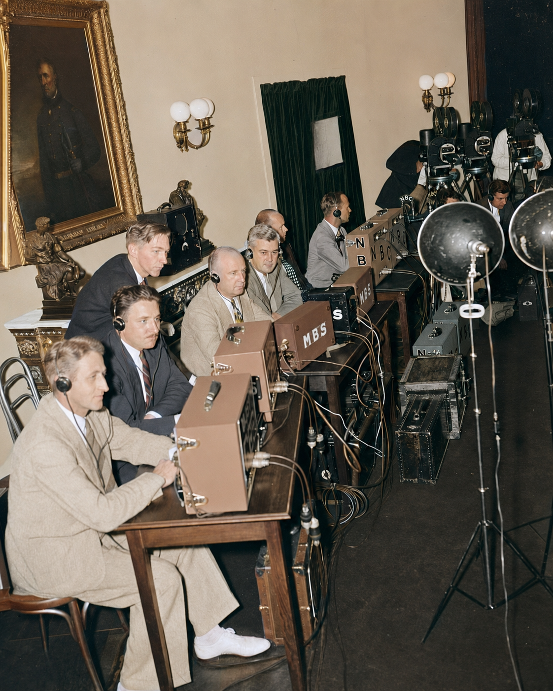 Radio operators wearing headphones sit among network equipment, microphones and cables inside the White House, photographed in 1938 or 1939.