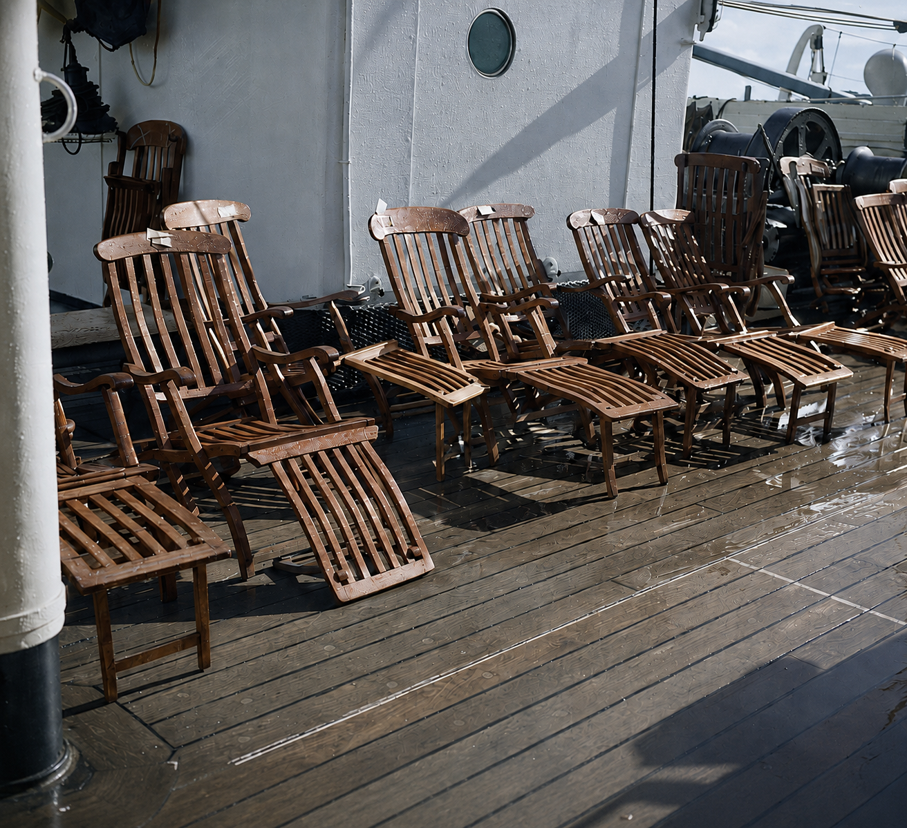 Rows of empty wooden and canvas steamer chairs on the promenade deck of the liner Athenia, photographed in 1937.