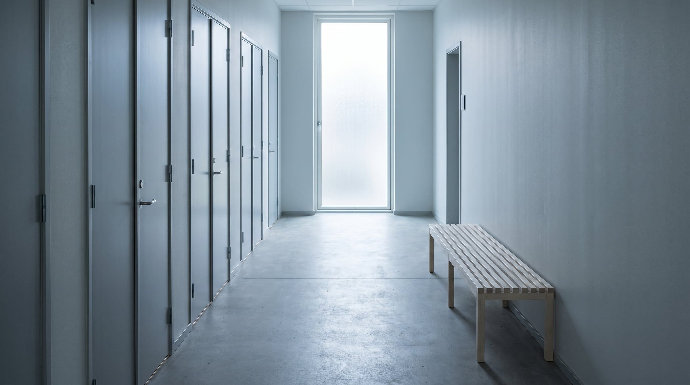 An empty corridor of closed office doors in a public building