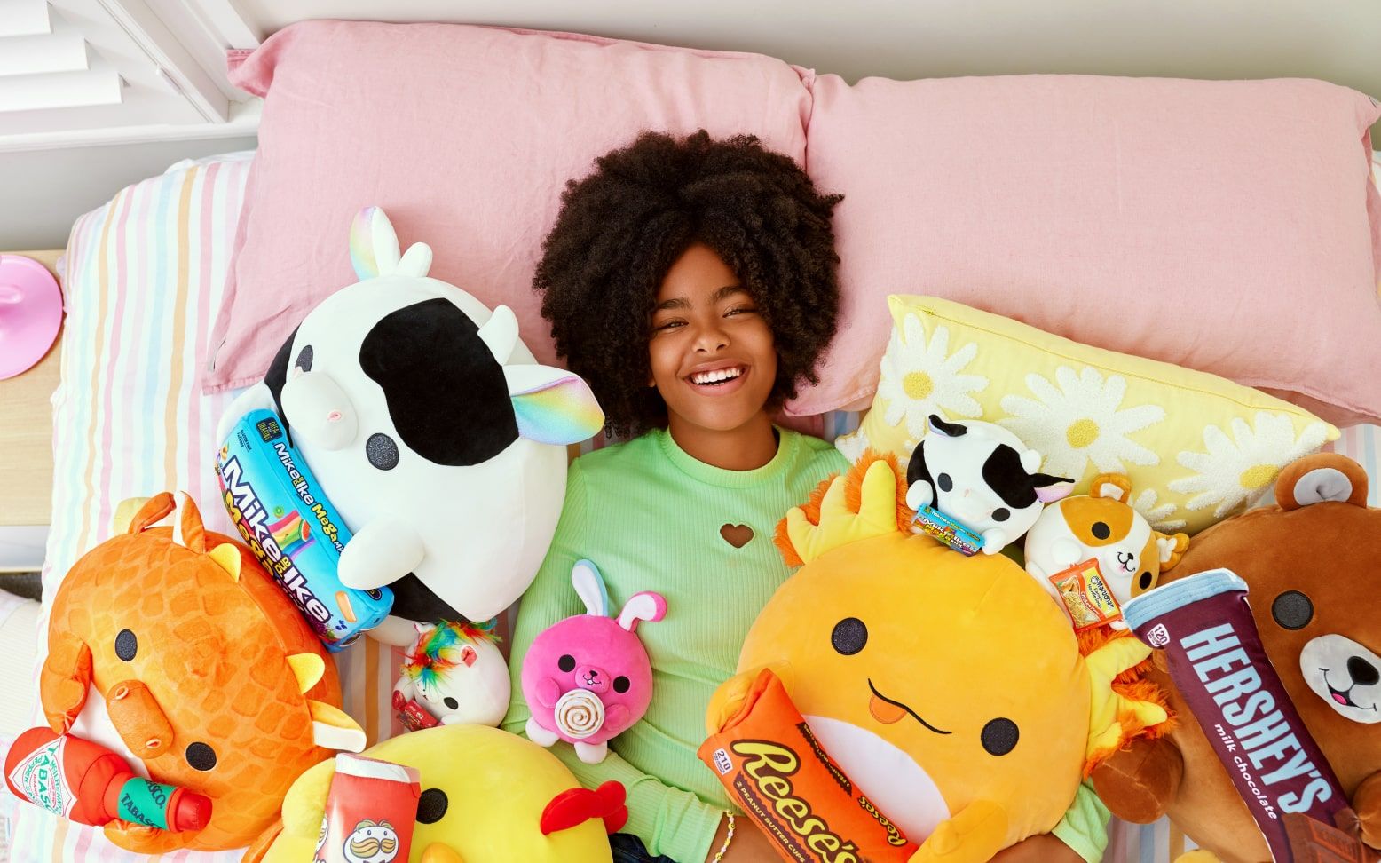 Girl laying on pile of snackles plushies | ZURU Toys