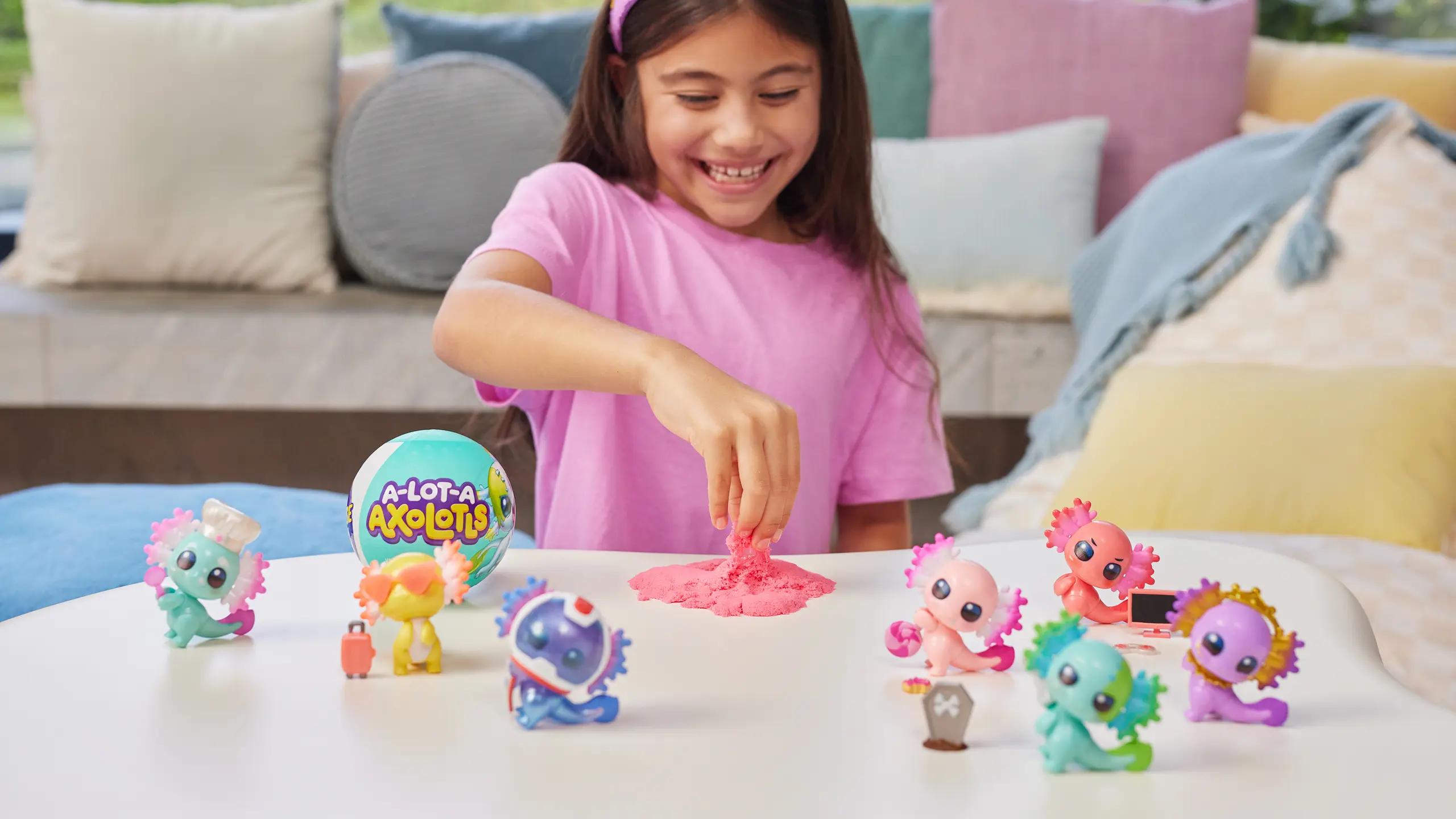 Person playing with a range of A-Lot-A-Axolotls toys, and a magic sand textured toy