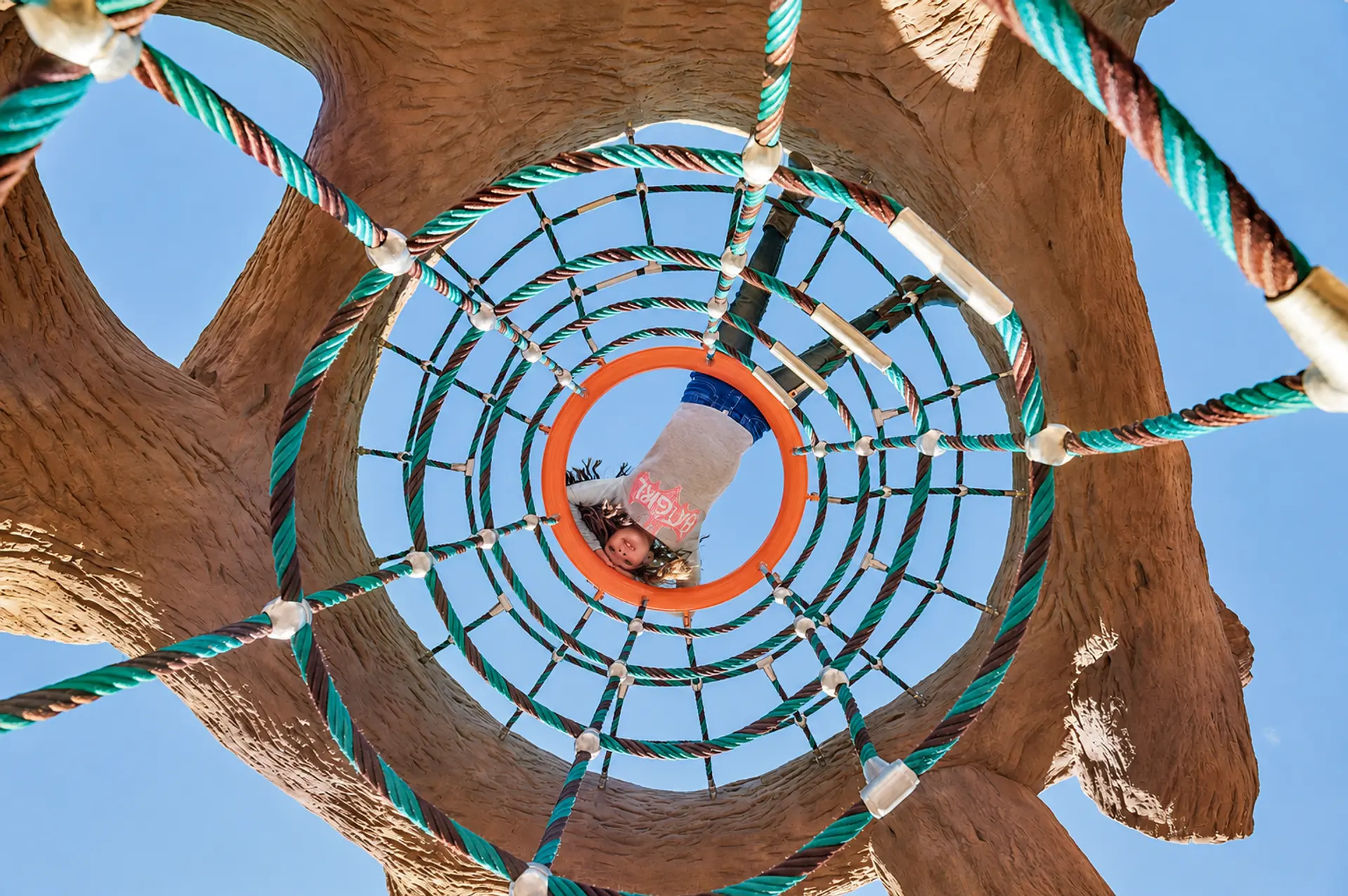 Child in a rope climbing net, seen from below