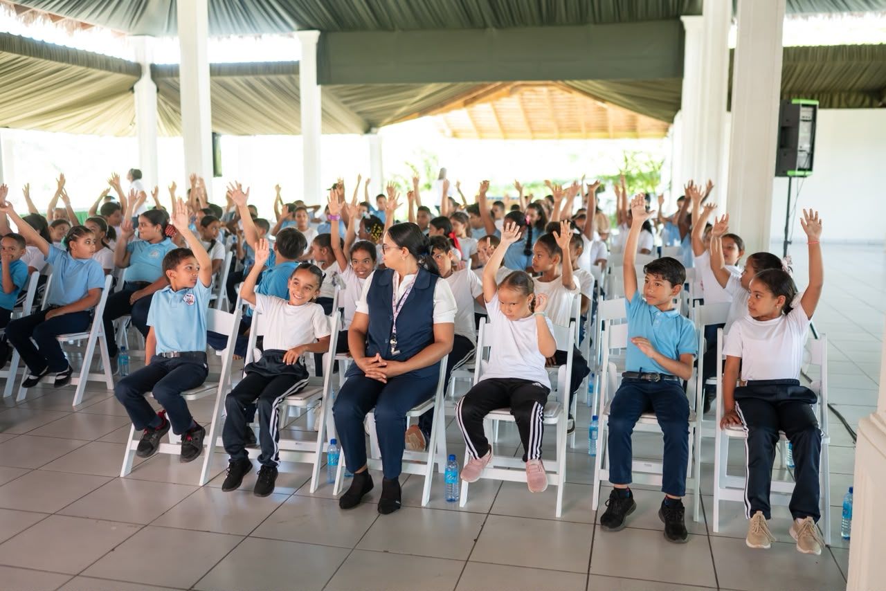 Las niñas y los niños levantan la mano para participar.