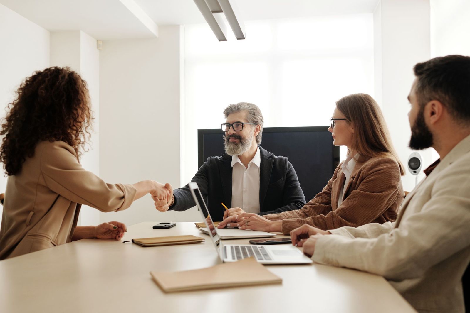 Dos personas se dan la mano en una reunión de trabajo.