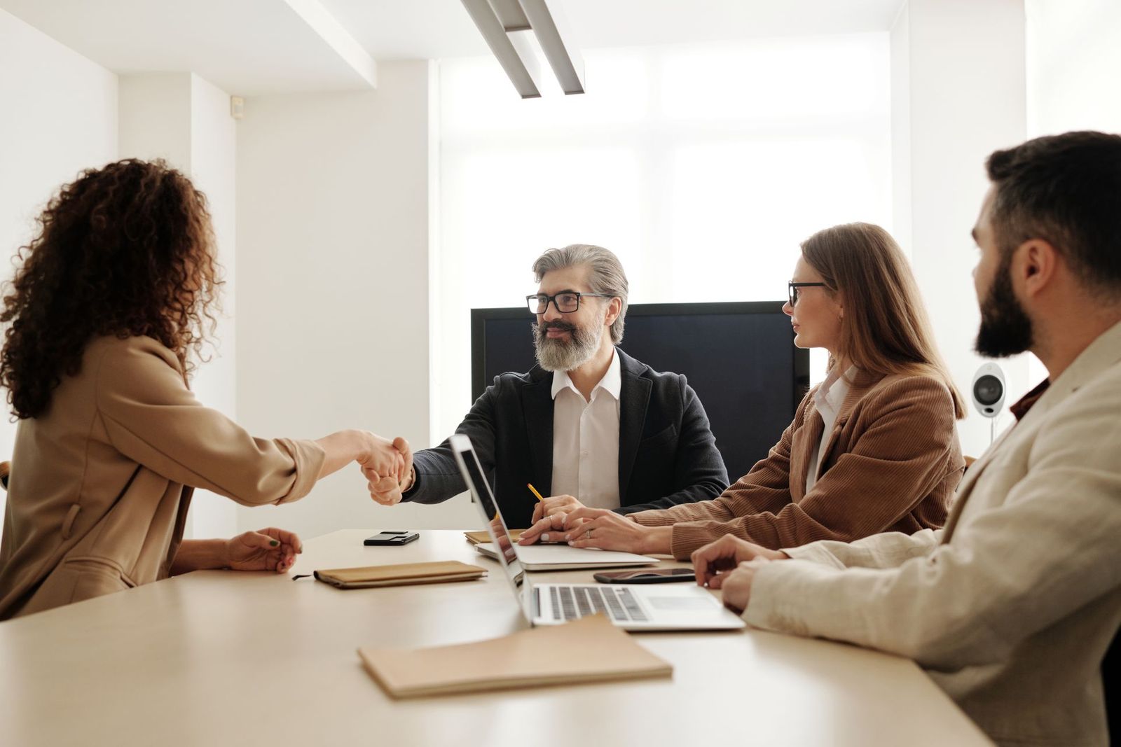 Dos personas se dan la mano en una reunión de trabajo.