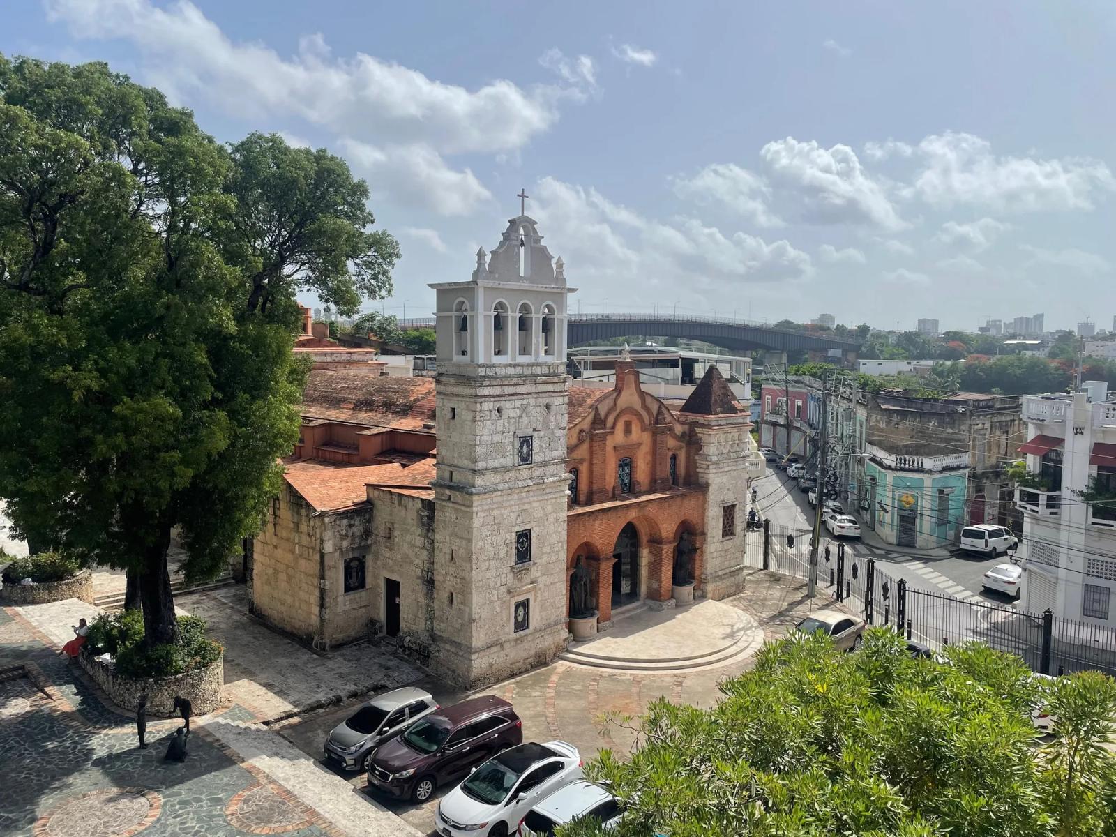 Una iglesia colonial de piedra con su campanario, en una plaza de Santo Domingo, vista desde lo alto.