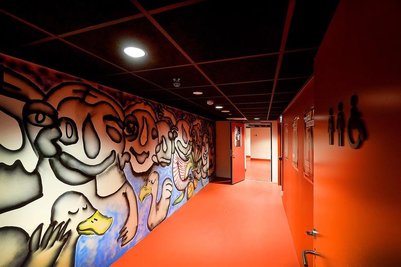 photo of red hallway with spray painted art on the left wall