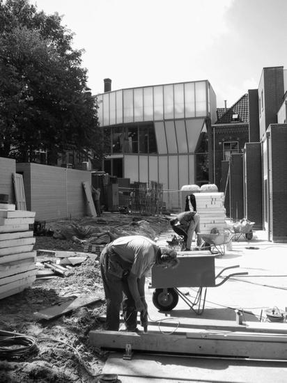 Black and white photo from construction site with worker in the shot. 