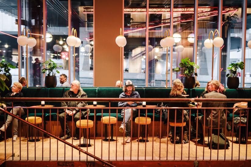 Photo of cafe with green velvet sofa and windows towards the street