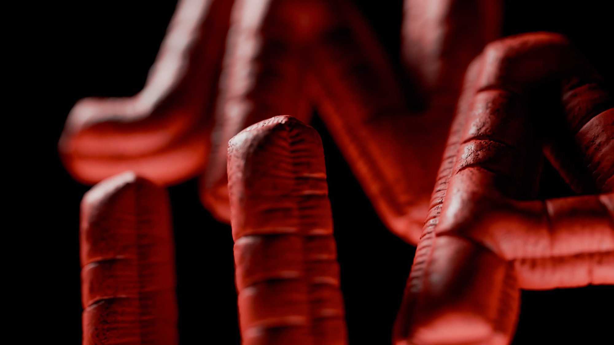 Close-up of the red, ribbed 3D letters of the Junca logo on black