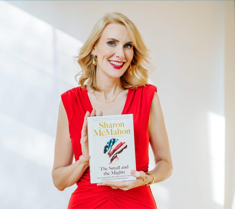 Sharon McMahon in a red dress holding The Small and the Mighty