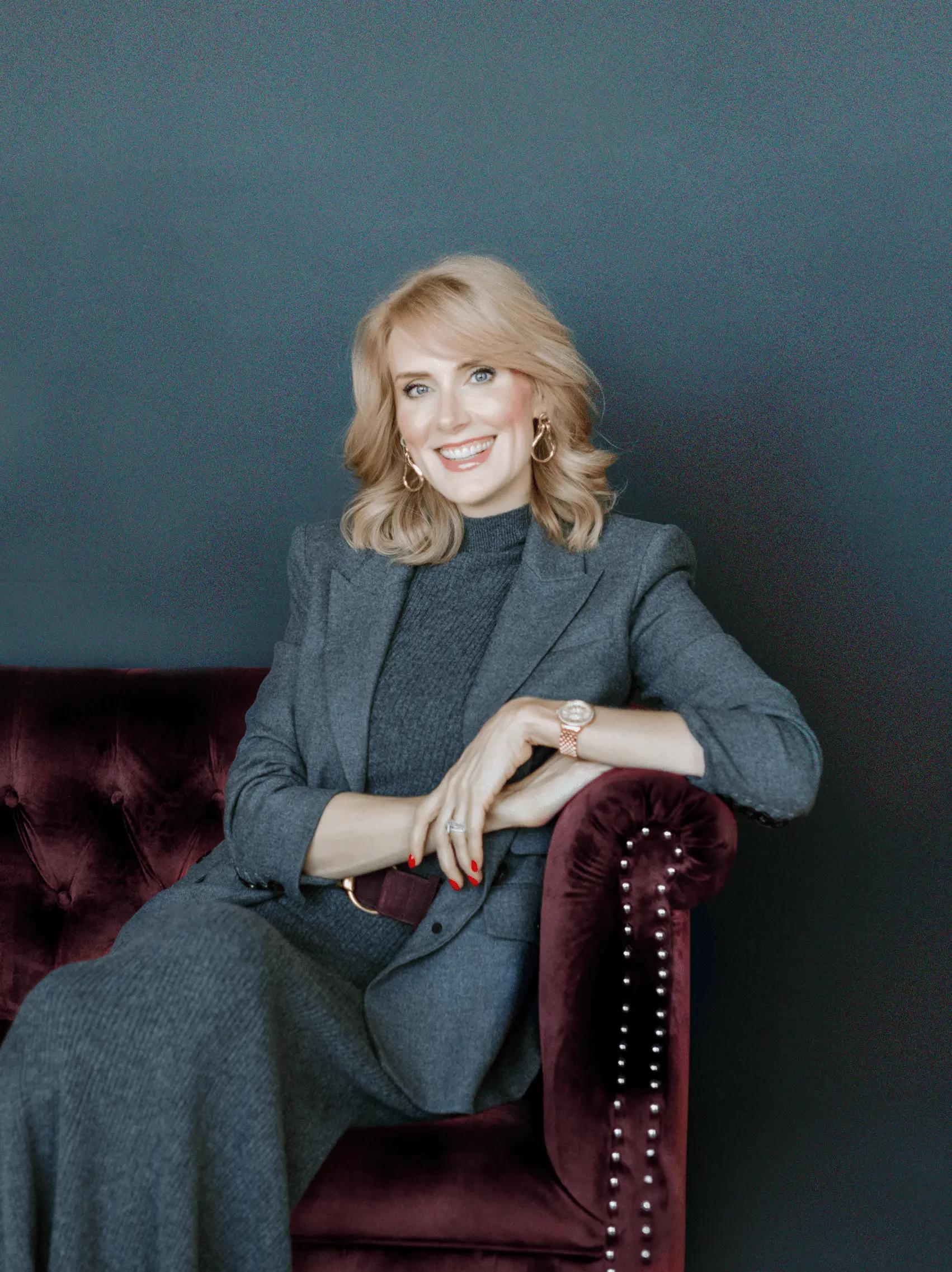 Sharon McMahon on a couch, smiling