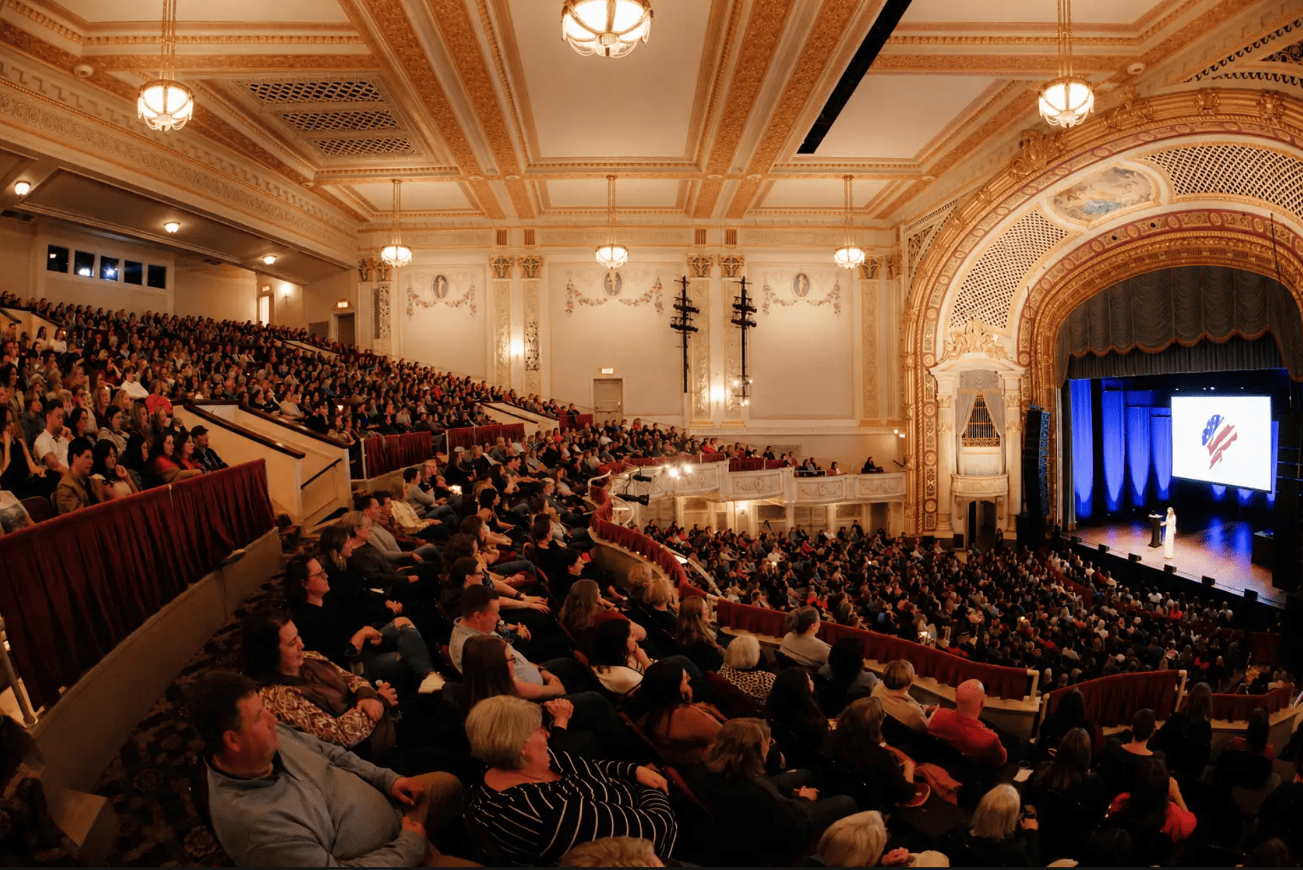 Sharon McMahon speaking to a packed theater