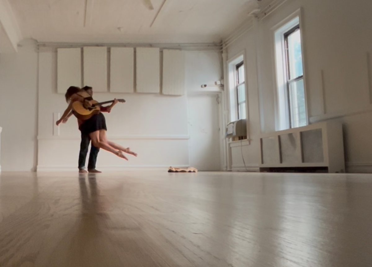 Two dancers partnering in a bright white studio