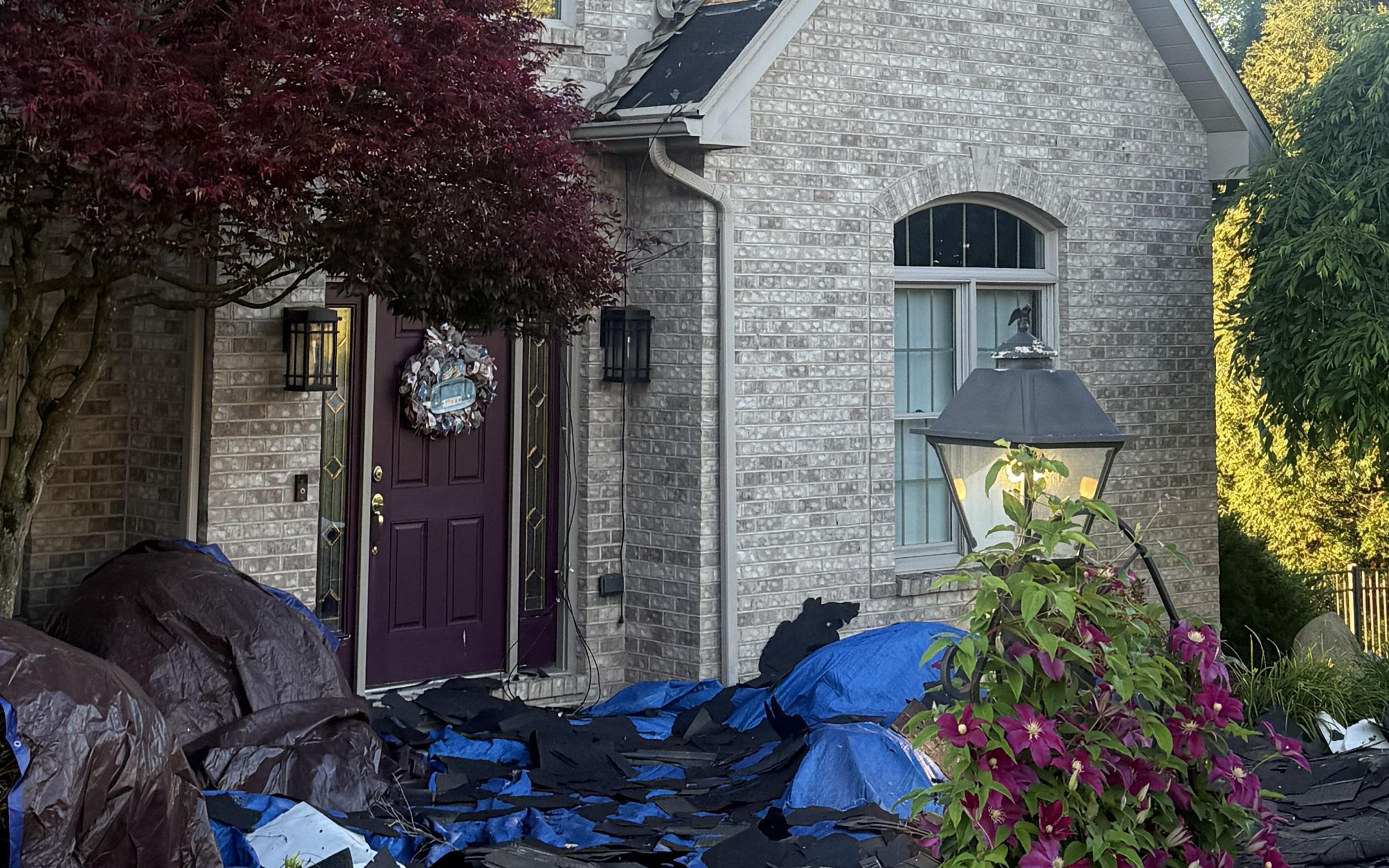 Full tarp coverage protecting landscaping during a roof tear-off