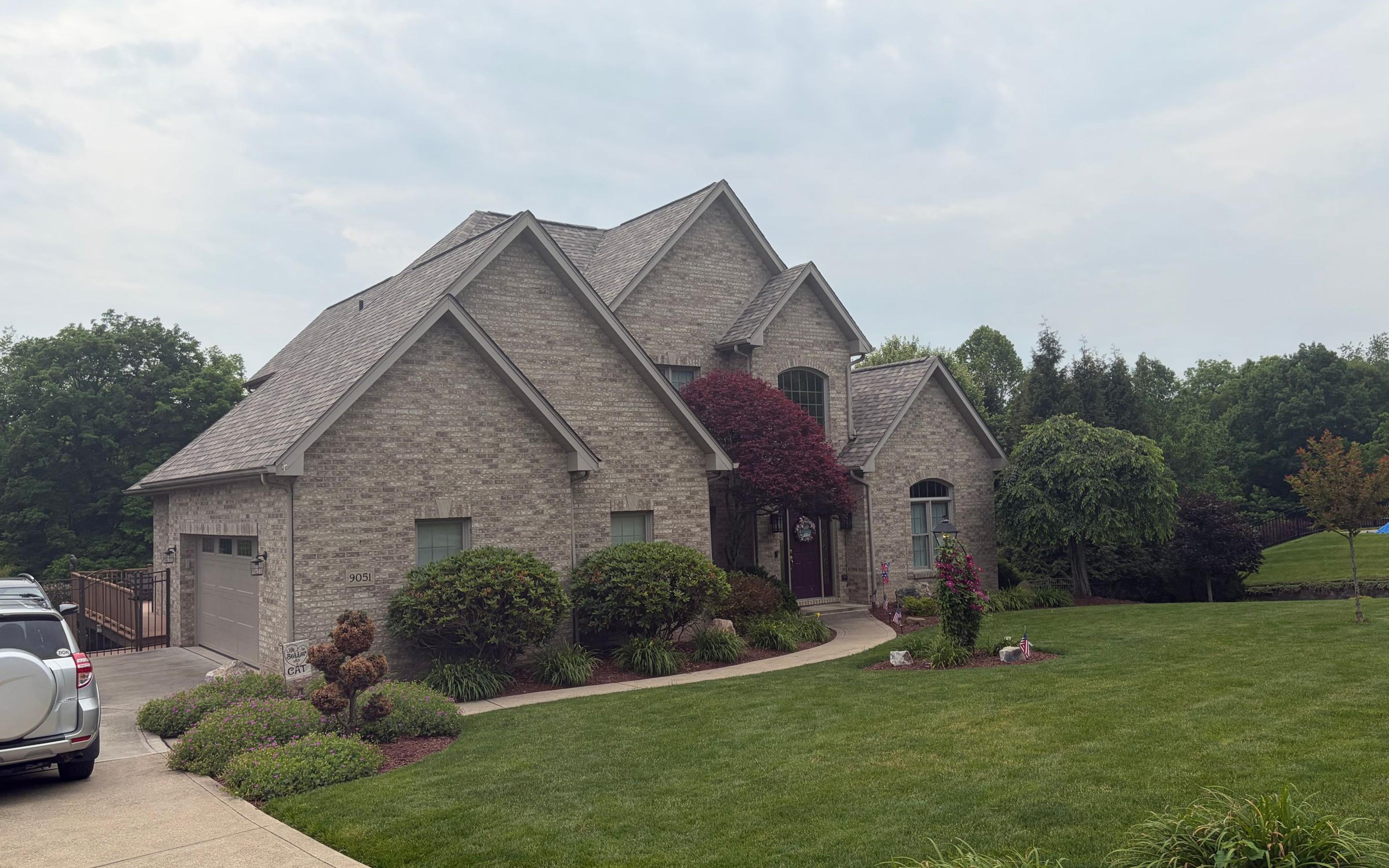 Completed roof replacement on a large brick home