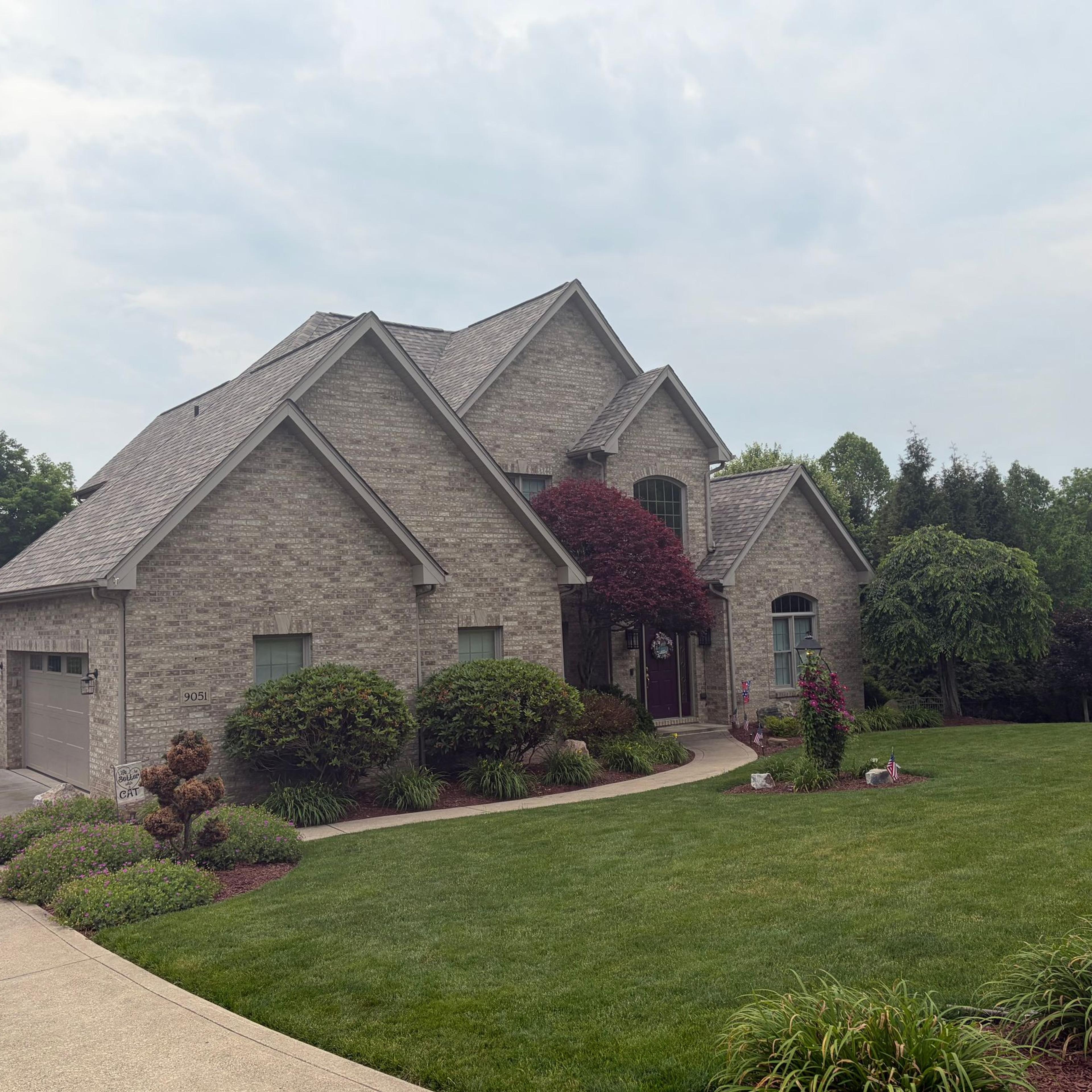 Completed roof replacement on a large brick home
