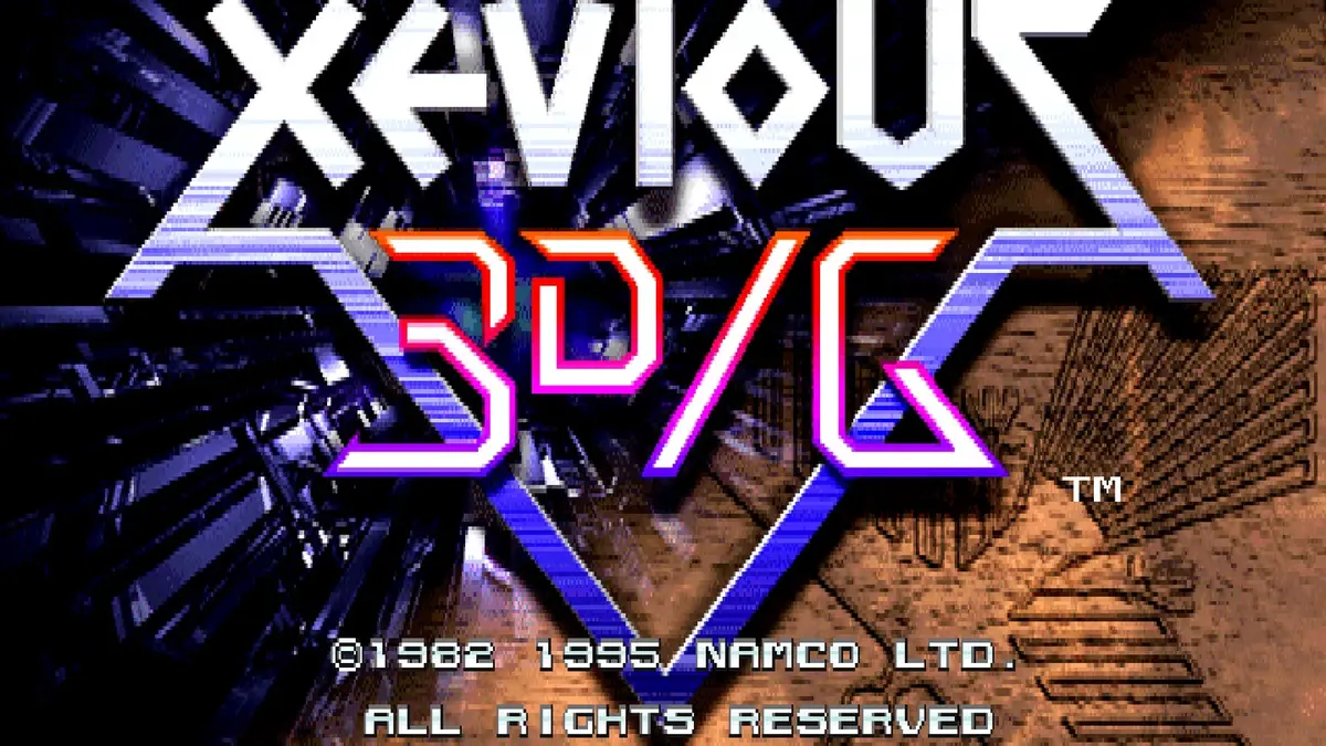 The title screen of Xevious 3D/G, its chunky chrome and pink logo sitting on a blue polygonal background above the Namco copyright line