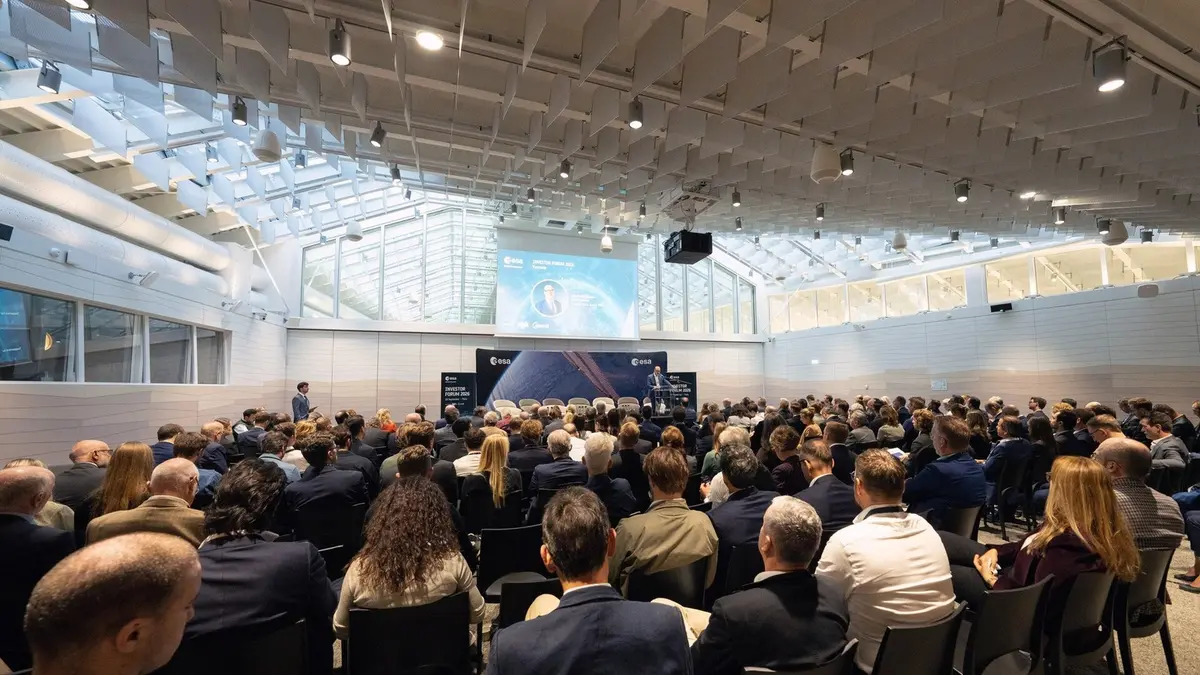 A packed auditorium at ESA headquarters in Paris during the Investor Forum 2026, with delegates seated in rows facing a stage where a speaker stands beside a screen showing an ESA portrait and the event's branding.