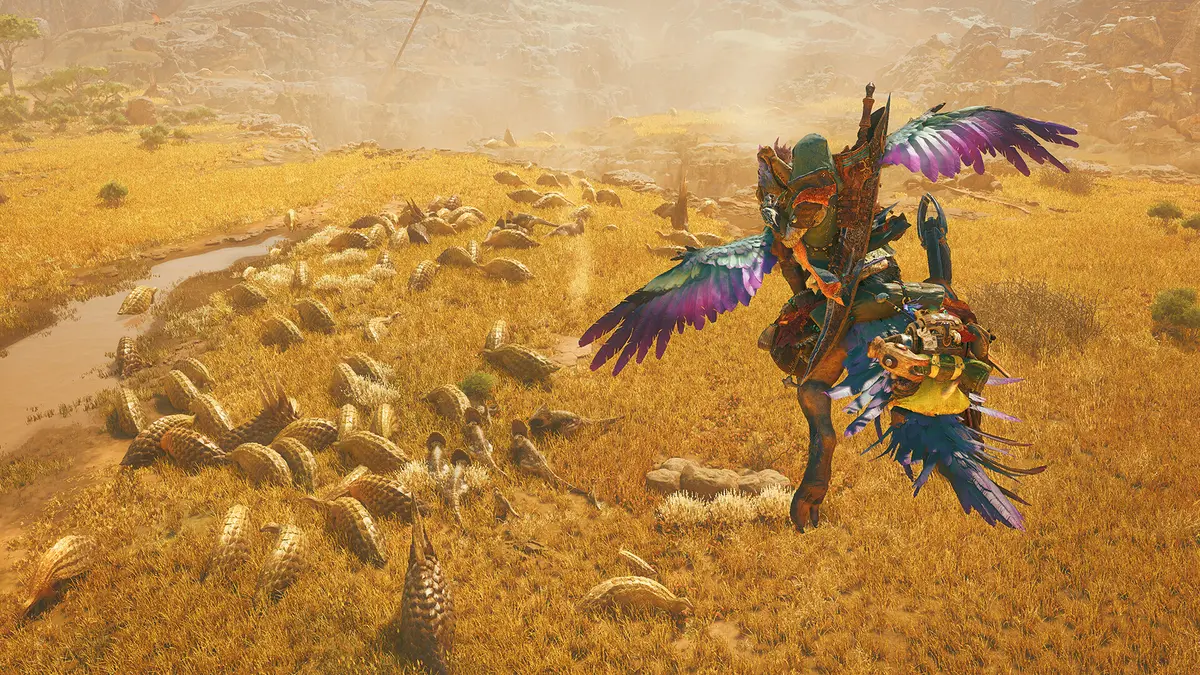 A Monster Hunter Wilds hunter rides a plumed seikret across a golden plain dotted with grazing herbivores.