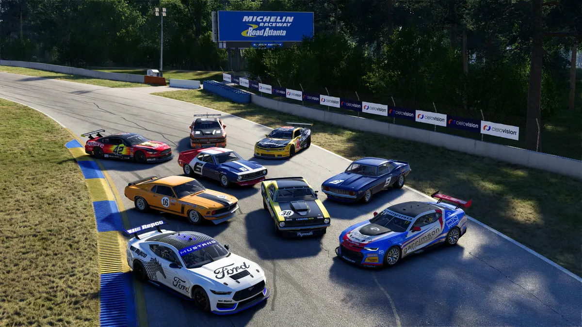 A grid of nine V8 race cars — historic American muscle, modern USV8 machinery and Australian V8 Evo cars — lined up on the track at Michelin Raceway Road Atlanta.
