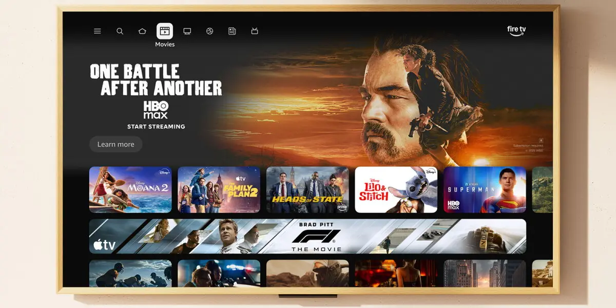 An Amazon Fire TV home screen on a television, showing a Movies row of streaming posters beneath the Fire TV logo
