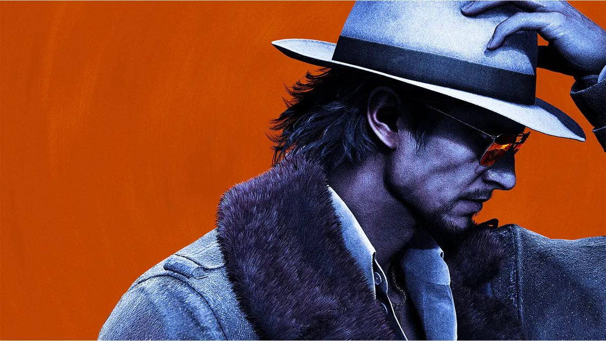 Makoto Daito in a fur-collared coat and fedora, one hand on the brim of his hat, against a bold orange backdrop in the *Stranger Than Heaven* key art