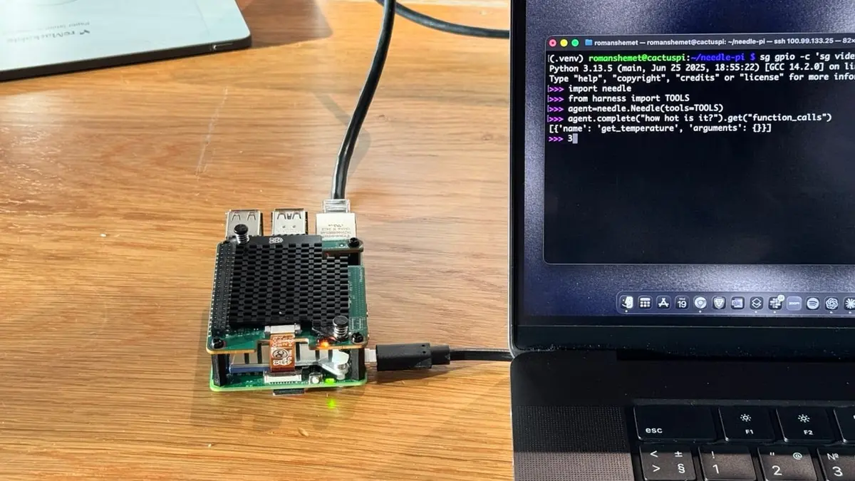 A Raspberry Pi 5 with a black heatsink powered on beside a laptop, its green activity LED lit, with a terminal window showing Python commands that import the Needle library and return a get_temperature function call