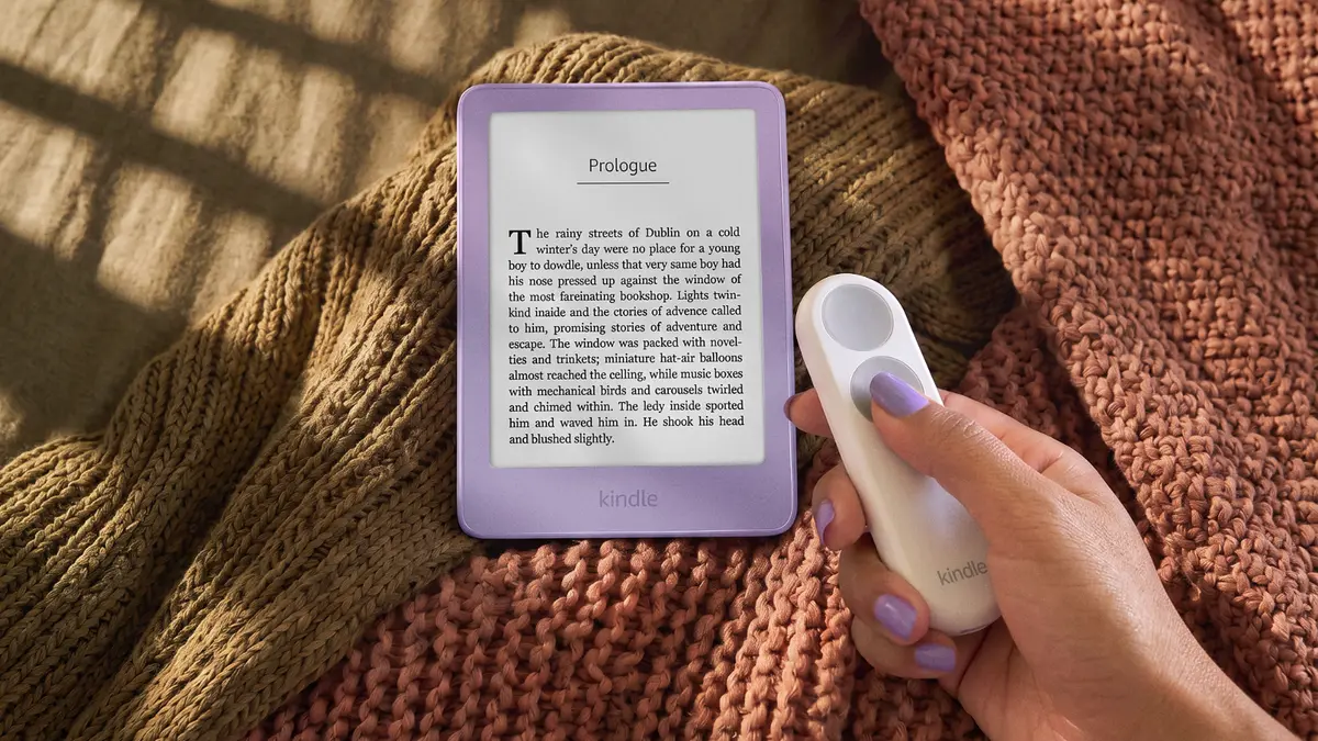A purple Kindle e-reader showing the opening page of a book, held beside Amazon's white Kindle Click Bluetooth remote with its page-turn and brightness buttons.