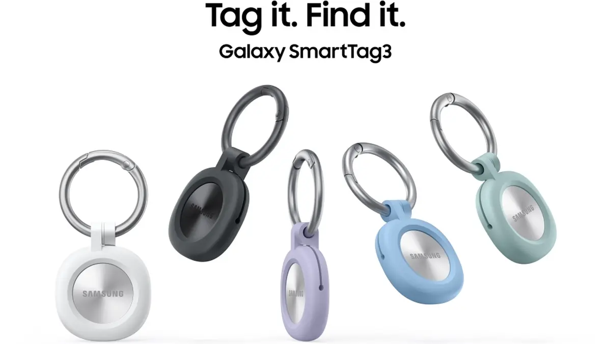Five Galaxy SmartTag3 trackers in white, black, blue, purple and mint hanging from keyrings, each with a silvered round face stamped Samsung