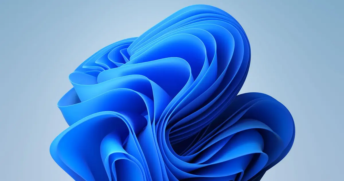 The Windows 11 bloom artwork: an abstract blue flower of light against a dark blue background