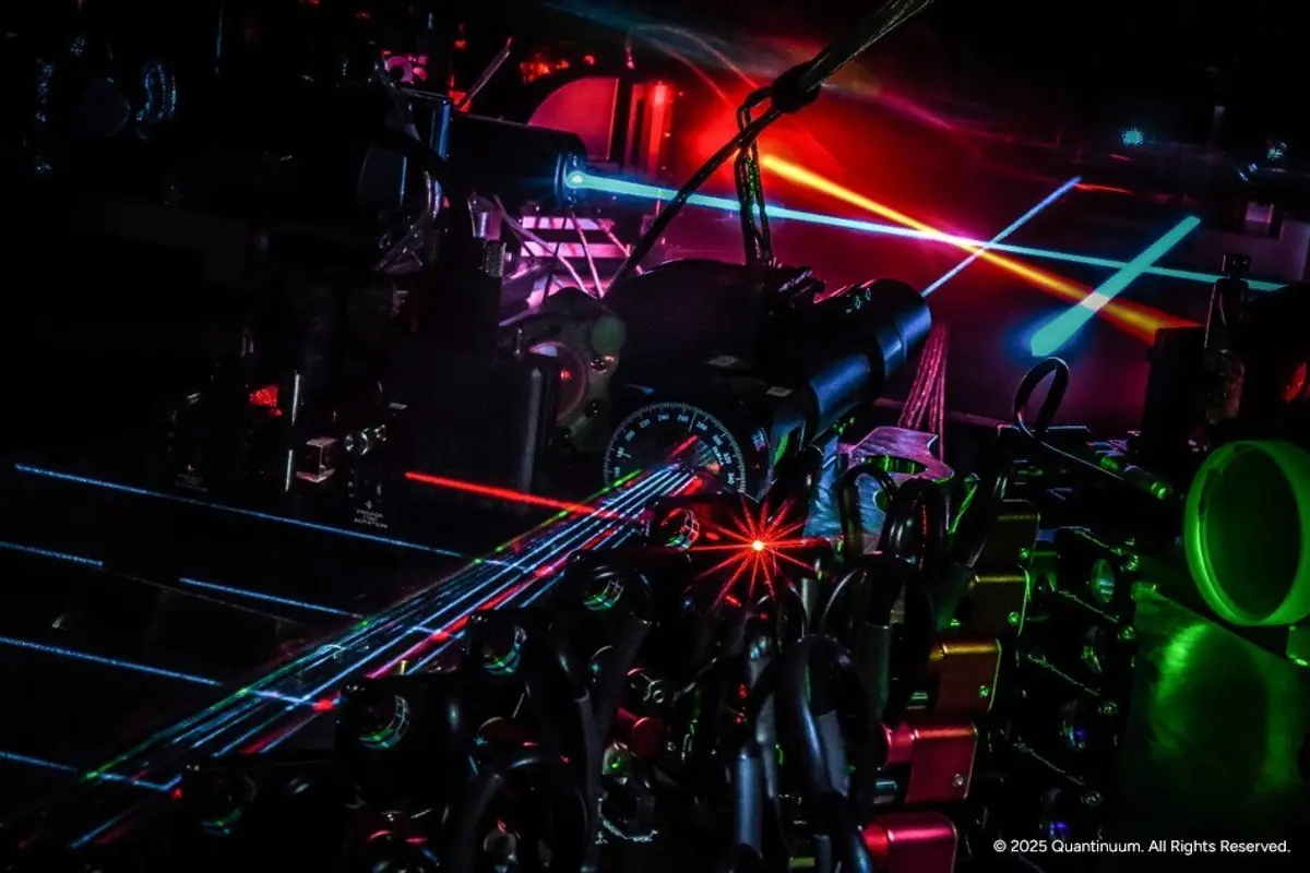 Supplied Quantinuum laboratory photograph showing quantum-computing hardware and colourful laser beams; © 2025 Quantinuum.