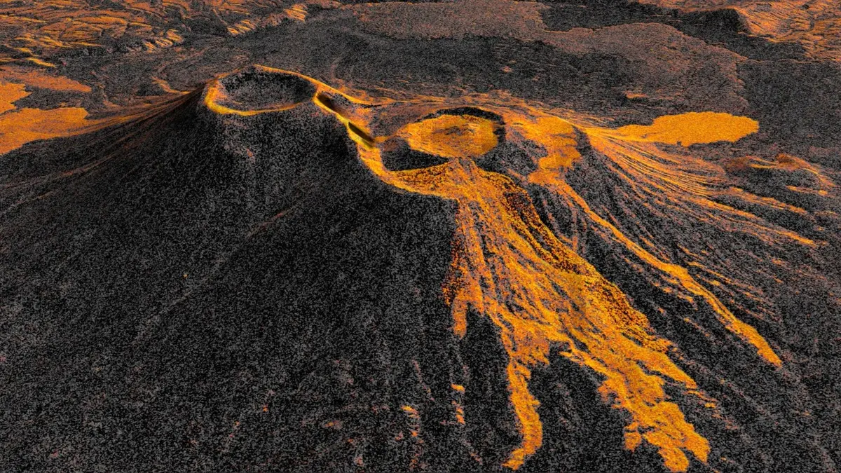 A radar image of the Krasheninnikov volcano in Kamchatka, its twin craters ringed in bright orange lava that fans out across the dark grey terrain