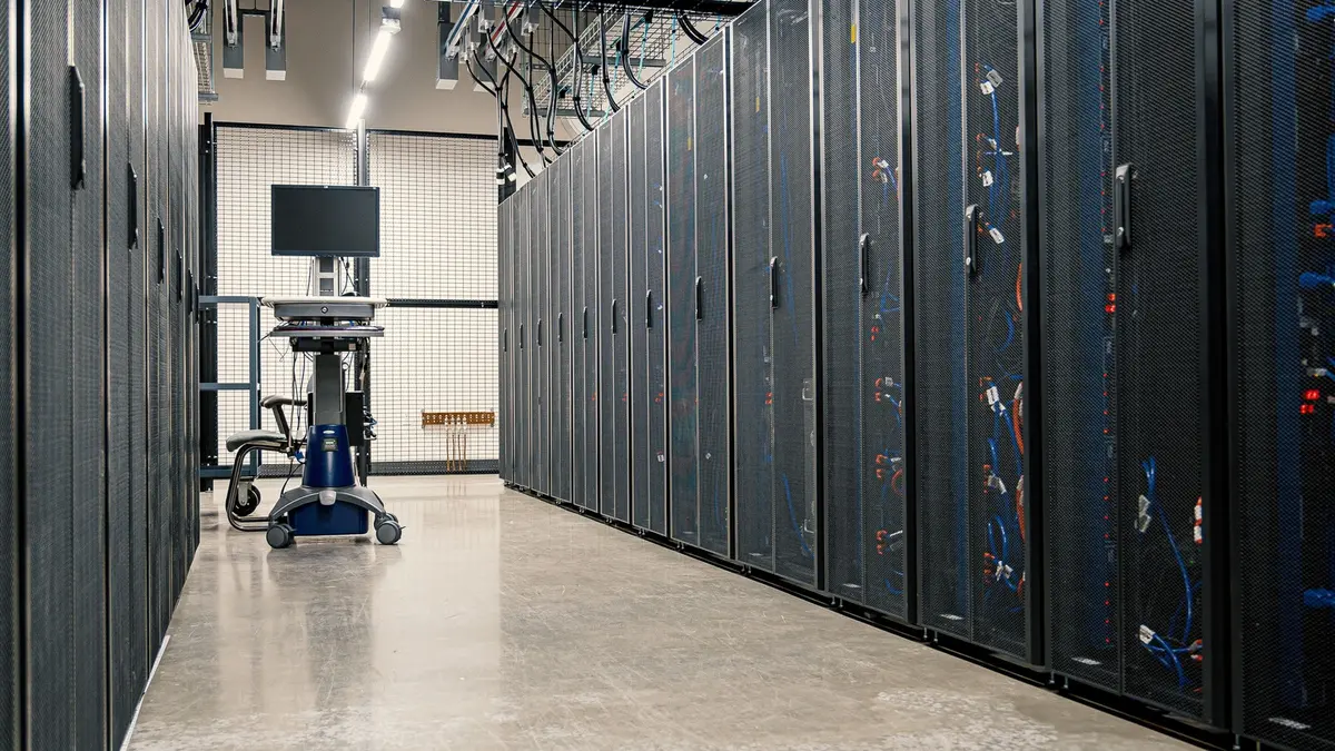 Rows of illuminated server racks lining a data centre aisle