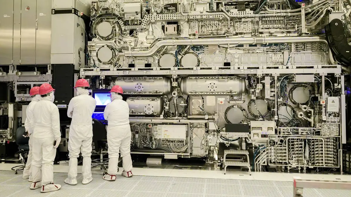 Official Intel newsroom photograph showing technicians in cleanroom suits working beside a High-NA EUV lithography system.