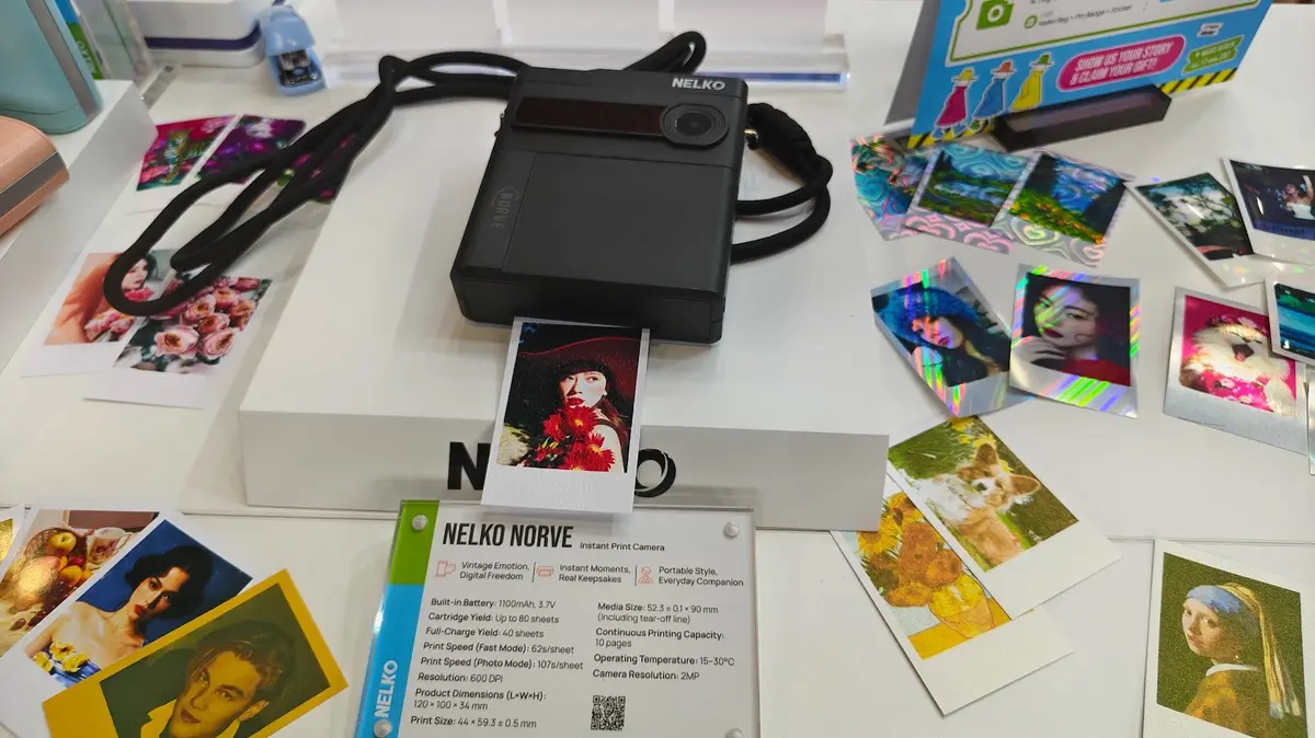 Nelko Norve instant print camera displayed at IFA 2026, surrounded by colourful photo samples and creative media, with its product specification card visible in the foreground.