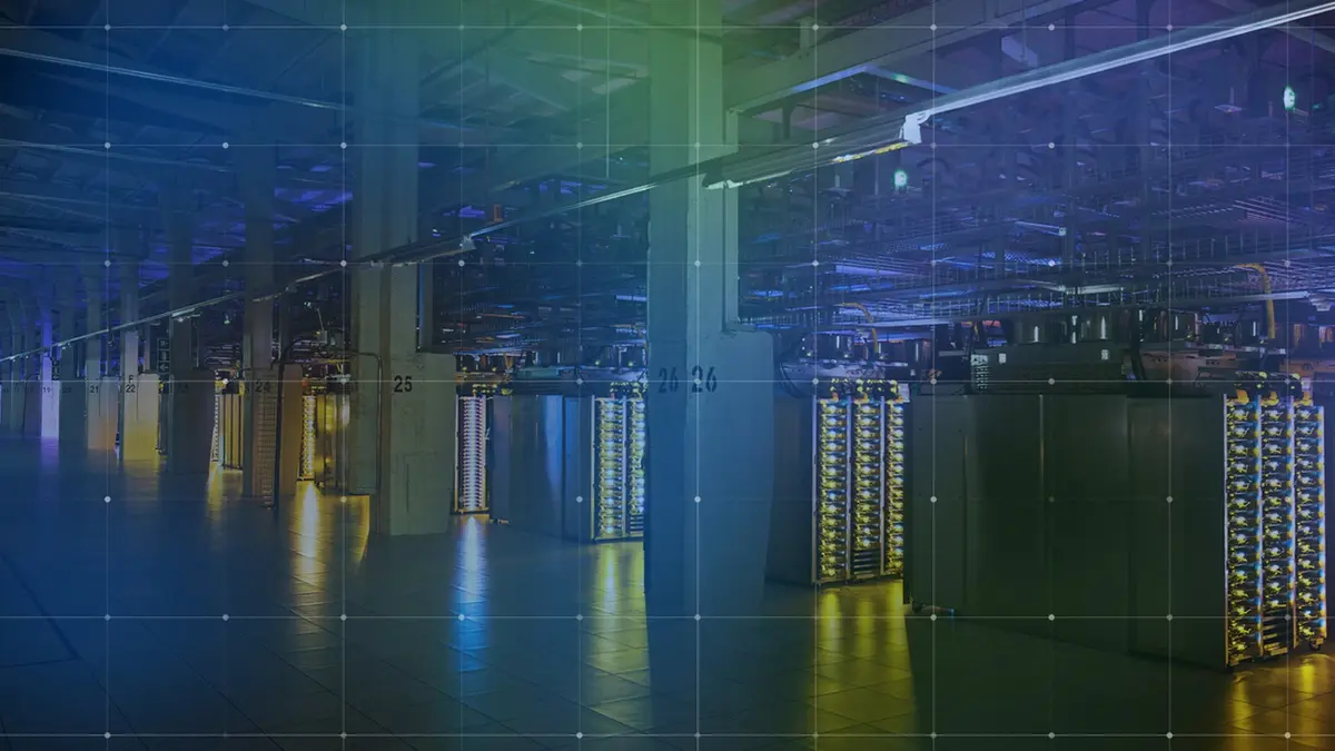 A long, dimly lit data-centre aisle of server racks lit in blue and gold, overlaid with a faint white grid.