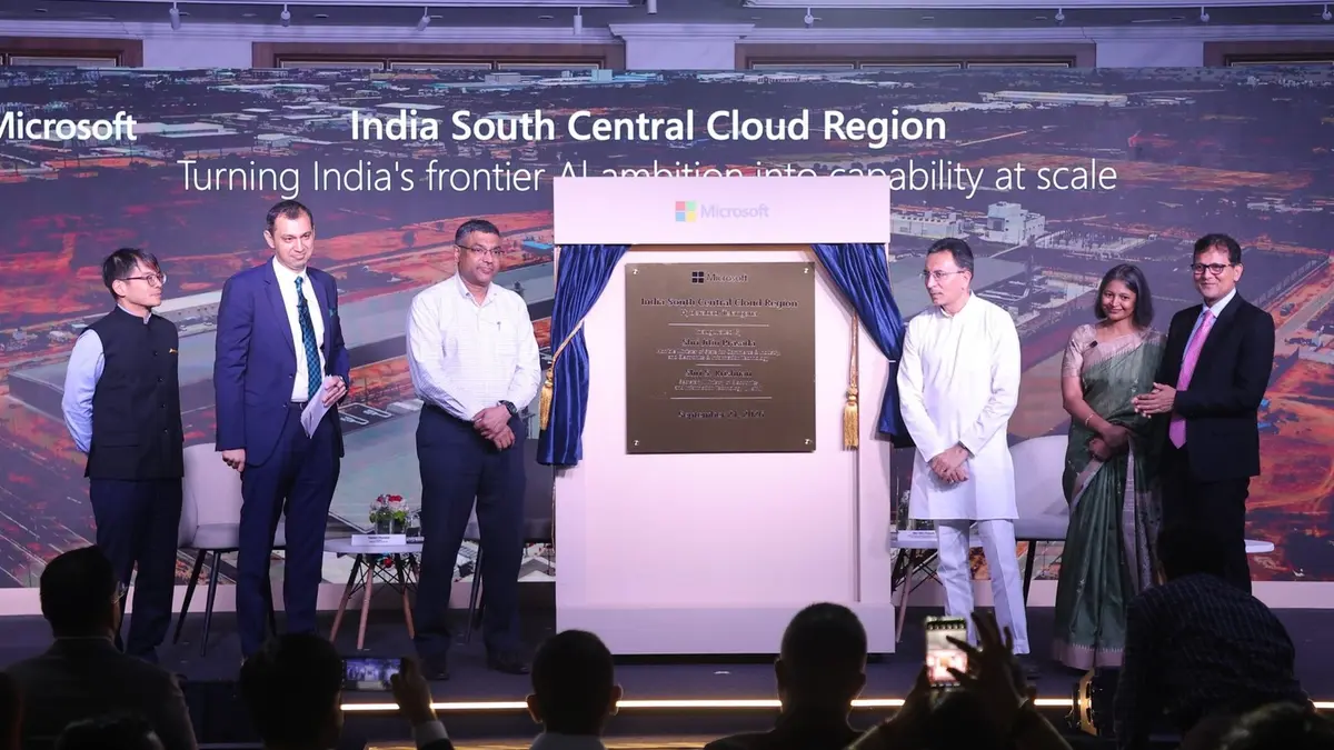 Officials and Microsoft executives on a stage unveiling a commemorative plaque for the India South Central cloud region, with a screen behind them showing an aerial view of the Hyderabad site and the words India South Central Cloud Region