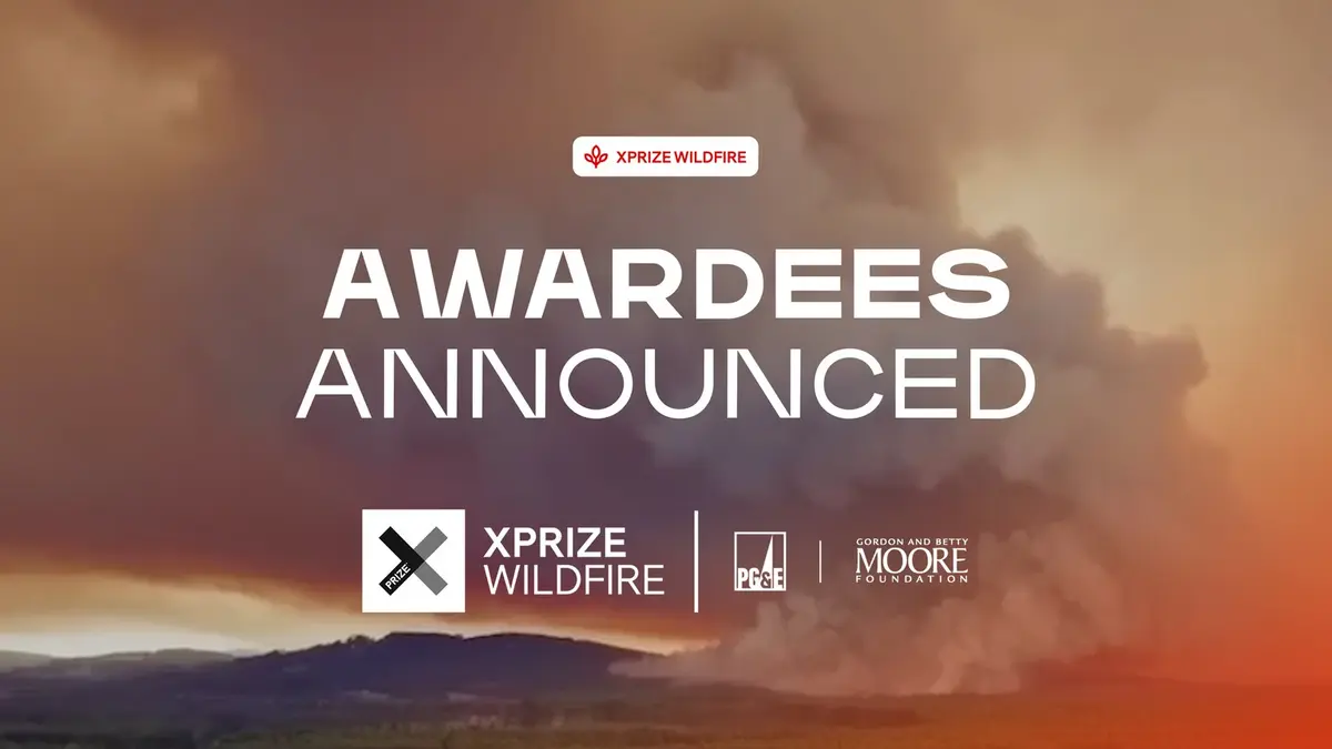 XPRIZE's awardee announcement graphic: the words AWARDEES ANNOUNCED in white capitals across a photograph of thick orange-brown wildfire smoke, with an XPRIZE Wildfire badge above and the XPRIZE Wildfire, PG&E and Gordon and Betty Moore Foundation logos along the bottom.