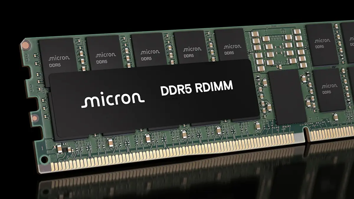 A Micron DDR5 RDIMM server memory module with a metal heatspreader and memory chips visible, photographed at an angle against a dark background