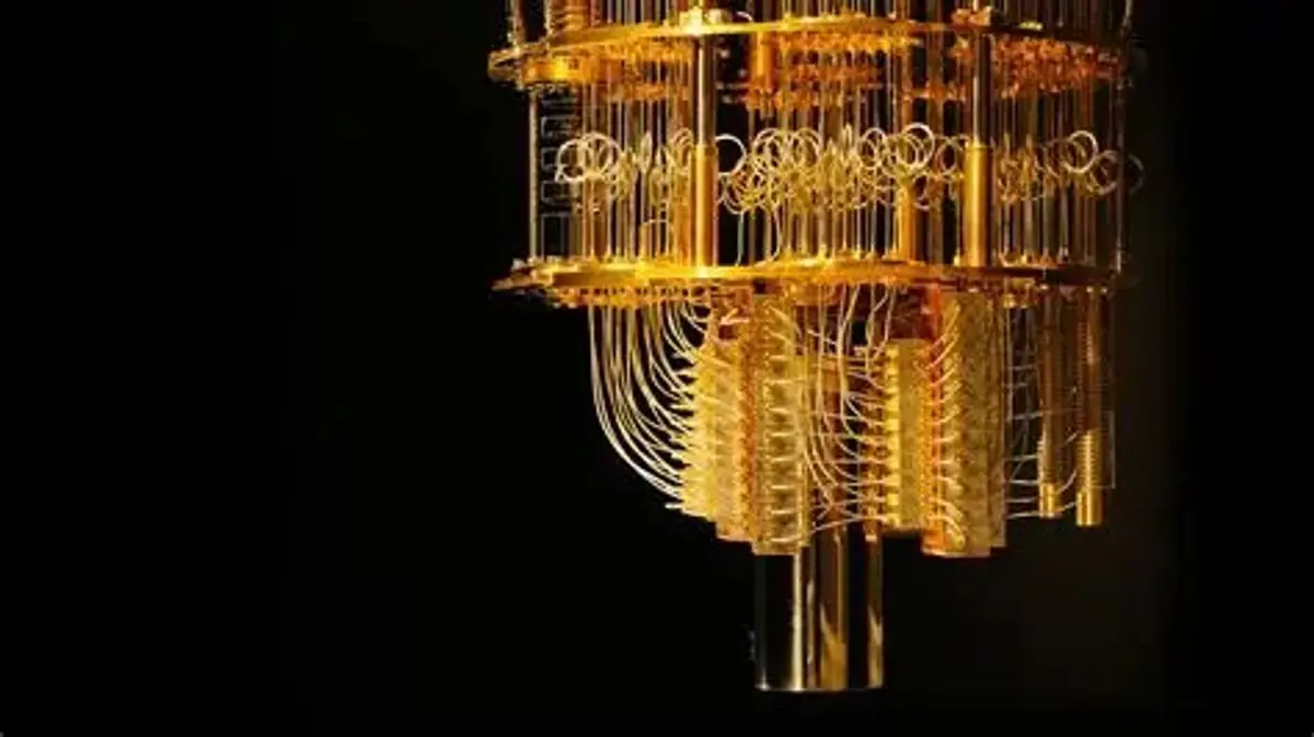 Supplied image of a gold-coloured superconducting quantum computer chassis with layered wiring and cooling structures.