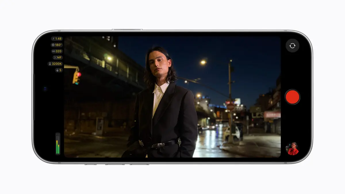 Final Cut Camera running on an iPhone 18 Pro with a filmmaker framed in the viewfinder and the app's shutter angle, ISO, white balance and zoom readouts stacked down the left of the screen